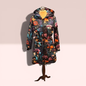 May include: A hooded jacket featuring a dark background with a vibrant floral print in shades of orange, red, pink, and teal. The jacket includes a full-length black front zipper, long sleeves, and a drawstring waist with black cords.