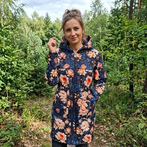 May include: A hooded jacket featuring a dark blue background with a vibrant floral pattern of peach and orange flowers. The jacket includes a full-length front zip, a drawstring waist, and two front pockets, extending to mid-thigh length.
