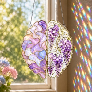 May include: A stained glass suncatcher shaped like a human brain, suspended by a metal chain. The left side features swirling purple and blue glass patterns, while the right side displays detailed white flowers and cascading purple wisteria blossoms.
