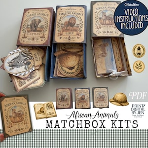 May include: Three rectangular matchbox kits featuring vintage-style illustrations of an elephant, lion, and cheetah. Each box contains paper ephemera, including animal-themed cards and a pith helmet cutout. Text includes "Tiny Book Library" and "Matchbox Video Instructions Included."