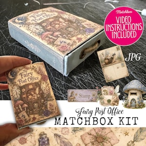 Op de afbeelding: Een Fairy Post Office luciferdoosjeskit met een rechthoekig doosje voorzien van een vintage illustratie van een feeënwoning, vergezeld van miniatuur ansichtkaarten, een postzegellabel en een afbeelding van een paddenstoelhuisje.