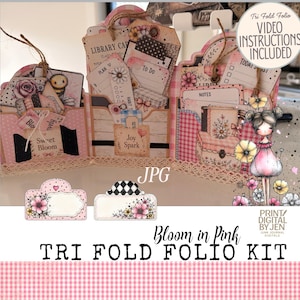 Könnte beinhalten: Ein dreifach faltbares Folio-Set mit rosa Vichy-Karomustern, Blumenillustrationen und verschiedenen Papieranhängern mit Texten wie Library Card, To Do, Joy Spark und Sweet Bloom. Das Set enthält eine Charakterillustration und Etiketten.