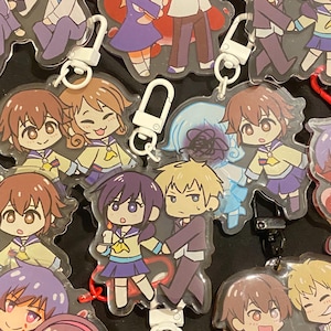 Puede incluir: Una colección de llaveros acrílicos estilo anime con varios personajes en uniformes escolares y ropa casual. Los llaveros tienen un acabado transparente y brillante e incluyen cierres metálicos. Los personajes están representados en un estilo colorido y caricaturesco.