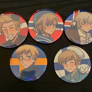 May include: Five circular pin badges with anime-style illustrations of characters, each set against a flag design. The badges have a holographic sheen and feature characters with diverse expressions and accessories, representing different nations.