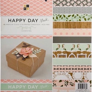 May include: A craft paper box tied with twine and decorated with a paper flower and leaves. The box is next to a stack of patterned paper sheets. The paper stack includes floral, geometric, and wood grain designs. The text "HAPPY DAY Stack" is visible.