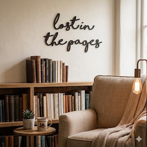 May include: A cozy reading nook featuring a wooden bookshelf filled with books, a comfortable armchair, and a small side table. The wall above the bookshelf displays the phrase "lost in the pages" in black script. A lamp with a warm light illuminates the scene.