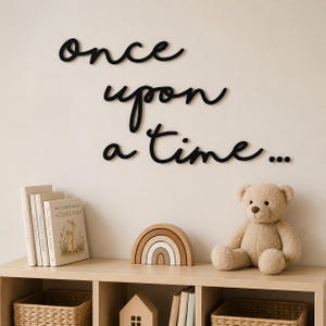 May include: A nursery scene with a wooden shelf displaying a teddy bear, books, a wooden rainbow, and a small house. The words "once upon a time..." are written in black script on the wall above the shelf.