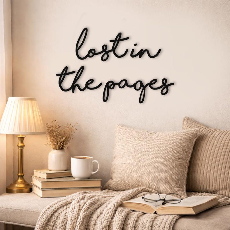 May include: A cozy reading nook with a wall sign that reads "lost in the pages." The scene includes a lamp, books, a mug, pillows, and an open book with glasses. The color palette is neutral with warm tones.