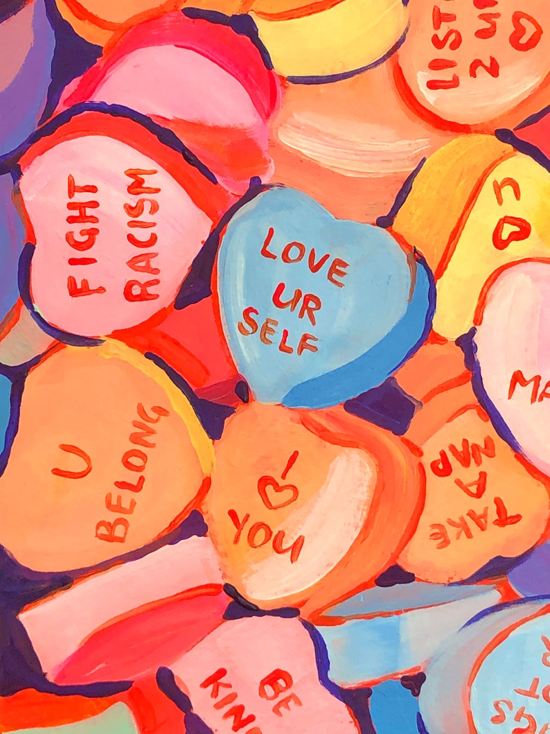 K&ouml;nnte beinhalten: Eine Sammlung herzf&ouml;rmiger S&uuml;&szlig;igkeiten mit verschiedenen Botschaften, die darauf gemalt sind, darunter "Fight Racism", "Love Ur Self", "U Belong", "Be Kind", "Take A Nap" und "I Love You".