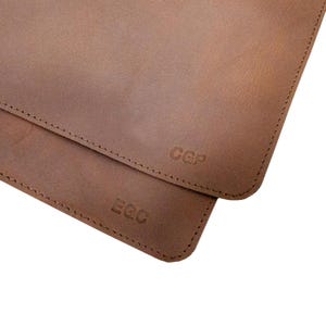 Rounded corners of a tan leather desk mat, close-up