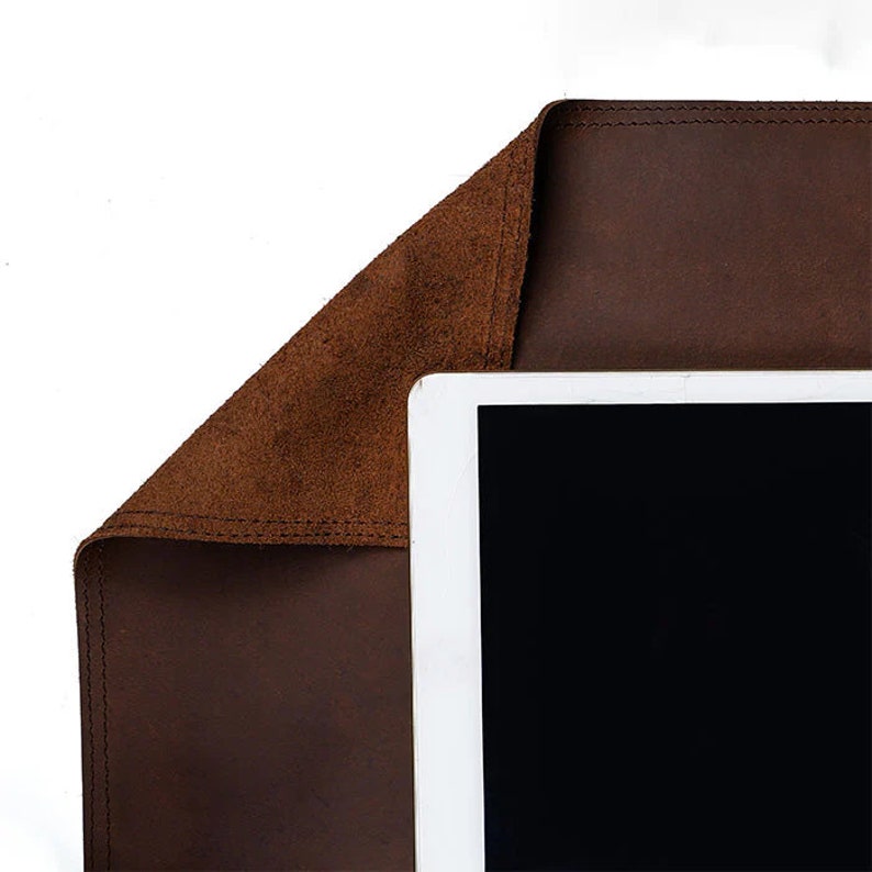 Brown leather desk mat edge folded over a tablet