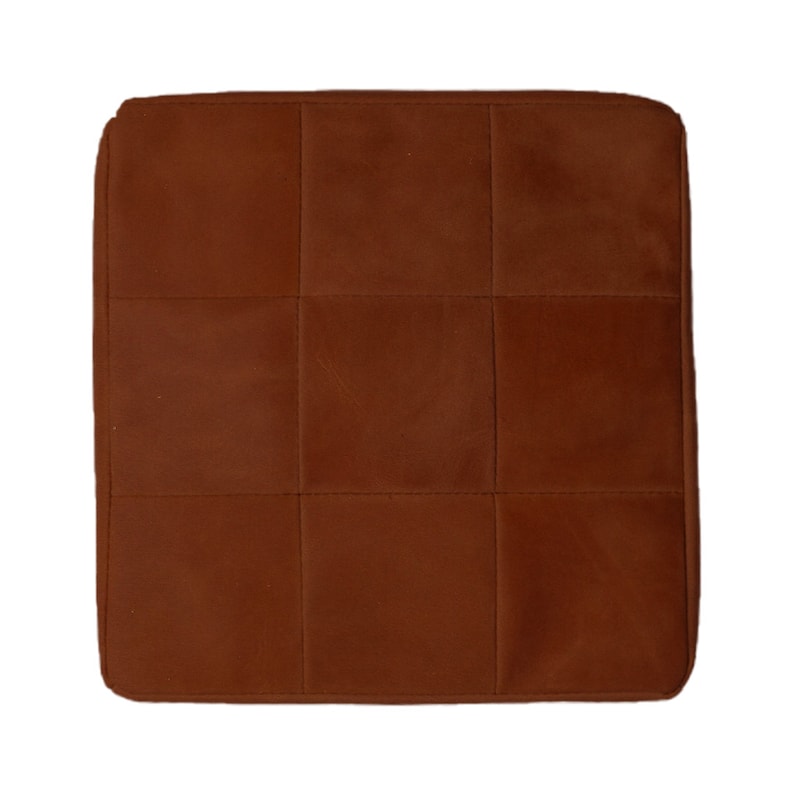 May include: A brown quilted cushion with a square shape.