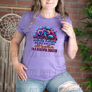 May include: Purple t-shirt with a floral design and the text "I'm beautifully broken perfectly imperfect beautiful in my flaws all together I'm a beautiful disaster".