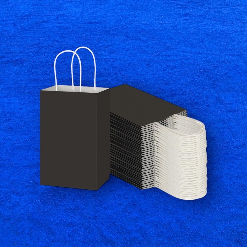 Op de afbeelding: Een stapel zwarte papieren tassen met witte handvatten. De tassen zijn in een stapel gerangschikt met de handvatten naar boven.