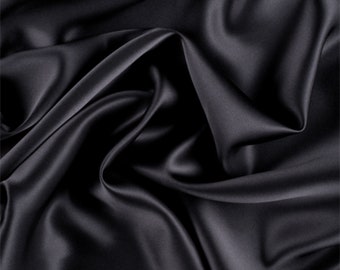 May include: A smooth, black satin fabric with a luxurious drape. The fabric is soft and silky to the touch.