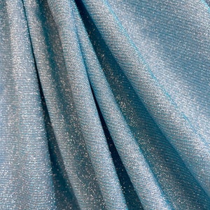 May include: Close-up of a light blue fabric with a silver shimmer. The fabric has a subtle texture and a soft, flowing drape.