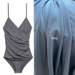 May include: A grey, sleeveless, one-piece swimsuit with a V-neck and a ruched design.