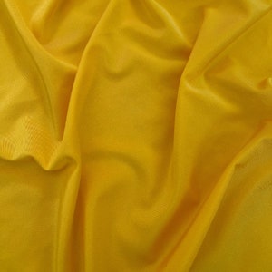 May include: A close-up of a smooth, yellow fabric with soft folds and wrinkles.