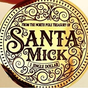 Puede incluir: Una moneda dorada con las palabras "SANTA MICK" en una fuente decorativa. La moneda tambi&eacute;n presenta el texto "FROM THE NORTH POLE TREASURY OF" y "1 JINGLE DOLLAR". La moneda tiene un borde adornado con volutas.