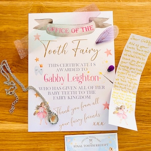 May include: A Tooth Fairy certificate, receipt, and note are displayed with a silver necklace. The certificate is addressed to Gabby Leighton and includes the text "Office of the Tooth Fairy." The receipt is for a final tooth, and the note is handwritten.