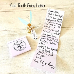 May include: A whimsical tooth fairy set includes a small glass bottle with gold glitter and a cork stopper, adorned with a tag reading "Fairy Dust." A folded letter and a small envelope with "Fairy Mail" are also present.