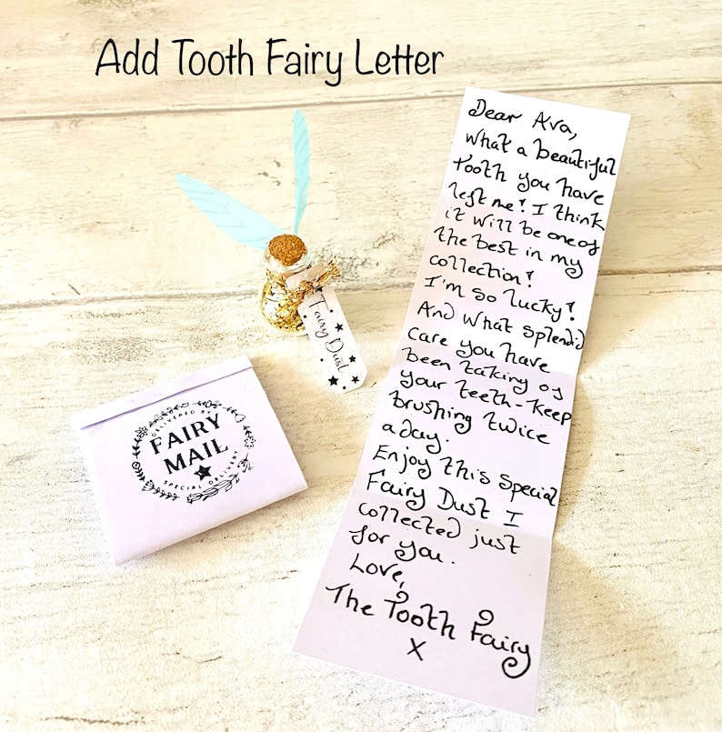 May include: A whimsical tooth fairy set includes a small glass bottle with gold glitter and a cork stopper, adorned with a tag reading "Fairy Dust." A folded letter and a small envelope with "Fairy Mail" are also present.