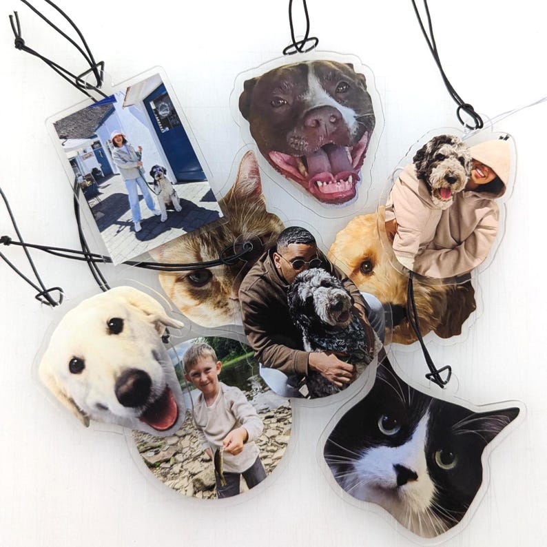 Puede incluir: Una colecci&oacute;n de adornos fotogr&aacute;ficos personalizados transparentes con varias mascotas y personas. Los adornos muestran im&aacute;genes de perros, gatos e individuos, cada uno con una forma &uacute;nica y una cuerda negra para colgar. Las fotos est&aacute;n impresas en pl&aacute;stico transparente.