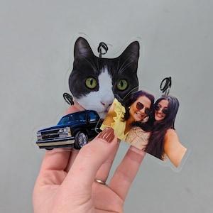 Puede incluir: Adornos fotogr&aacute;ficos personalizados de acr&iacute;lico transparente. Los adornos presentan una camioneta negra, una cara de gato en blanco y negro y una foto de dos mujeres. Cada adorno tiene un peque&ntilde;o lazo para colgar.
