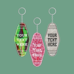 Puede incluir: Tres llaveros estilo motel con anillas y cadenas de metal plateado. El de la izquierda es de mármol verde y morado, el central es de purpurina rosa y el de la derecha es de mármol blanco. Cada uno tiene líneas y el texto YOUR TEXT HERE.