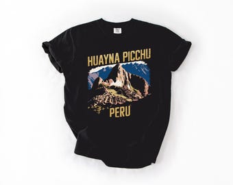 Puede incluir: Camiseta negra con un gráfico dorado de una cordillera y el texto "HUAYNA PICCHU PERU".