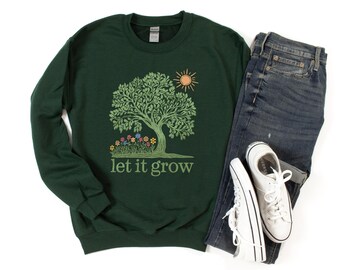 Puede incluir: Una sudadera verde oscuro con un gráfico de un árbol con un sol y el texto "let it grow".
