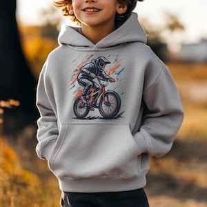 May include: A light gray hoodie featuring a graphic of a BMX biker in action. The biker is wearing a helmet and riding a red and orange bicycle. The design includes colorful brushstroke accents. The hoodie has a kangaroo pocket.