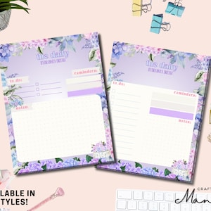 May include: Two floral-themed daily planner notepads with a purple and lavender color scheme. The notepads feature the text "the daily HYDRANGEA DREAM" and sections for to-do lists, reminders, and notes. The bottom of the notepads have a floral design. The text "AVAILABLE IN 2 STYLES!" is at the bottom.