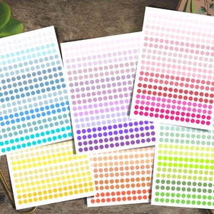 Peut inclure: Ensemble de 10 feuilles d'autocollants imprimables avec un dégradé de points colorés. Les feuilles présentent une variété de couleurs, notamment le bleu, le violet, le rose, le jaune, le vert et l'orange.