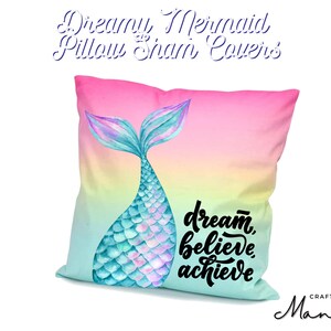 Peut inclure: Une taie d'oreiller avec un motif de queue de sirène turquoise aux écailles irisées sur un fond dégradé rose, jaune et vert. La taie d'oreiller porte le texte "dream, believe, achieve" en noir.