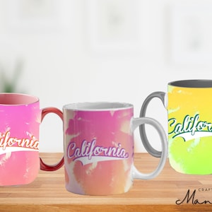 Könnte beinhalten: Drei Keramikbecher mit einem Aquarelldesign mit dem Wort "California" in einer Retro-Schrift. Die Becher sind in rosa, hellrosa und gelb.