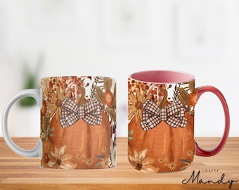 May include: A white ceramic mug with a red handle features a fall-themed design. The design includes a pumpkin with a plaid bow, surrounded by orange, brown, and yellow flowers. The text "Crafty Mandy" is visible at the bottom of the mug.