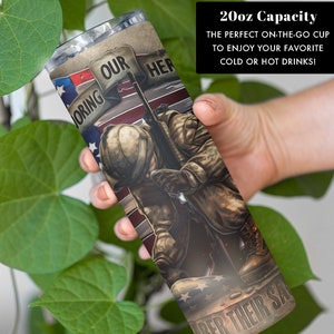 May include: A 20-ounce stainless steel tumbler with a patriotic design. It features a soldier kneeling in front of an American flag with the words "Honoring Our Heroes" and "Remember Their Sacrifice".