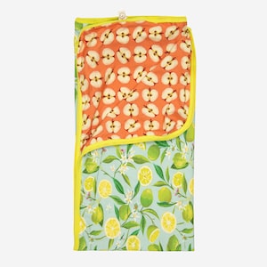 May include: A baby blanket with a bright yellow trim. The blanket features two distinct patterns: a light blue background with lemons and limes, and an orange background with apple slices. The blanket is made of soft fabric.