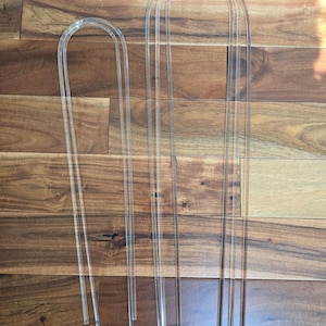 May include: Two sets of clear acrylic arches, one set is larger than the other. The arches are made of thin, clear acrylic and are perfect for creating a modern and minimalist look in your home decor.
