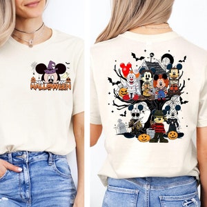 May include: A white t-shirt with a Mickey Mouse Halloween design on the front and a Halloween-themed Mickey Mouse and horror character design on the back. The shirt is being worn by a person with blue jeans.