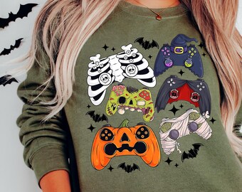 Op de afbeelding: Een groen sweatshirt met een Halloween-thema ontwerp met meerdere videogame controllers versierd met griezelige elementen zoals pompoenen, skeletten en mummies.