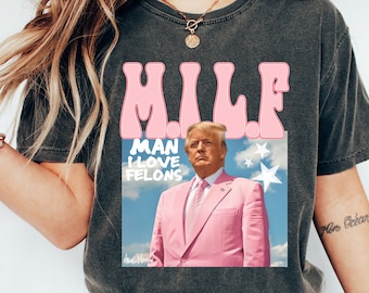 May include: A gray t-shirt with a pink graphic that says "MILF" and "MAN I LOVE FELONS". The graphic also features a portrait of Donald Trump in a pink suit.