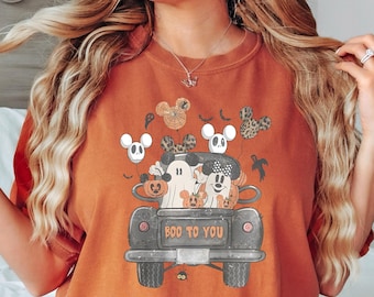May include: A rust-colored t-shirt with a graphic of Mickey Mouse and friends in a black car with the text "BOO TO YOU".