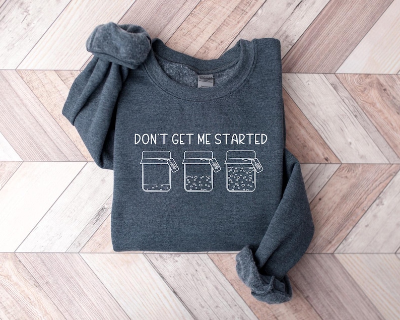 May include: A dark grey sweatshirt with the text "Don't get me started" and a graphic of three jars with lids.