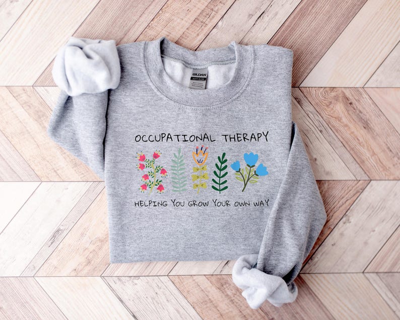 May include: Gray sweatshirt with the text "Occupational Therapy" and a graphic of colorful flowers with the text "Helping you grow your own way".