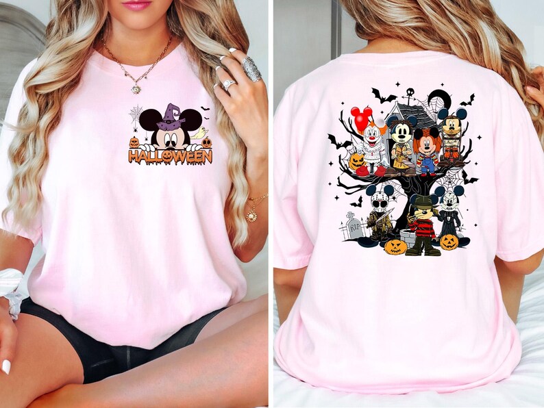May include: Pink t-shirt with a Halloween theme featuring Mickey Mouse and other characters. The front of the shirt has a cartoon of Mickey Mouse with a witch's hat and the word "HALLOWEEN". The back of the shirt has a cartoon of Mickey Mouse and other characters in a spooky tree.