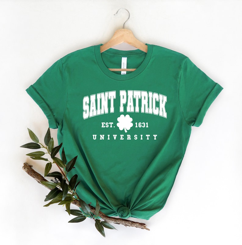 Puede incluir: Camiseta verde con texto blanco que dice "Saint Patrick University Est. 1631" con un gr&aacute;fico de tr&eacute;bol.