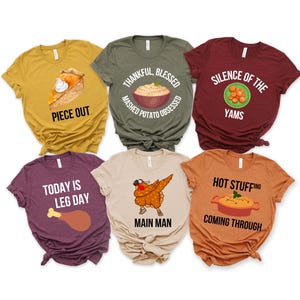 Op de afbeelding: Zes verschillende Thanksgiving-thema t-shirts. De shirts zijn allemaal met korte mouwen en hebben verschillende Thanksgiving-gerelateerde ontwerpen en tekst, waaronder "Piece Out", "Thankful, Blessed, Mashed Potato Obsessed", "Silence of the Yams", "Today is Leg Day", "Main Man" en "Hot Stuffing Coming Through".