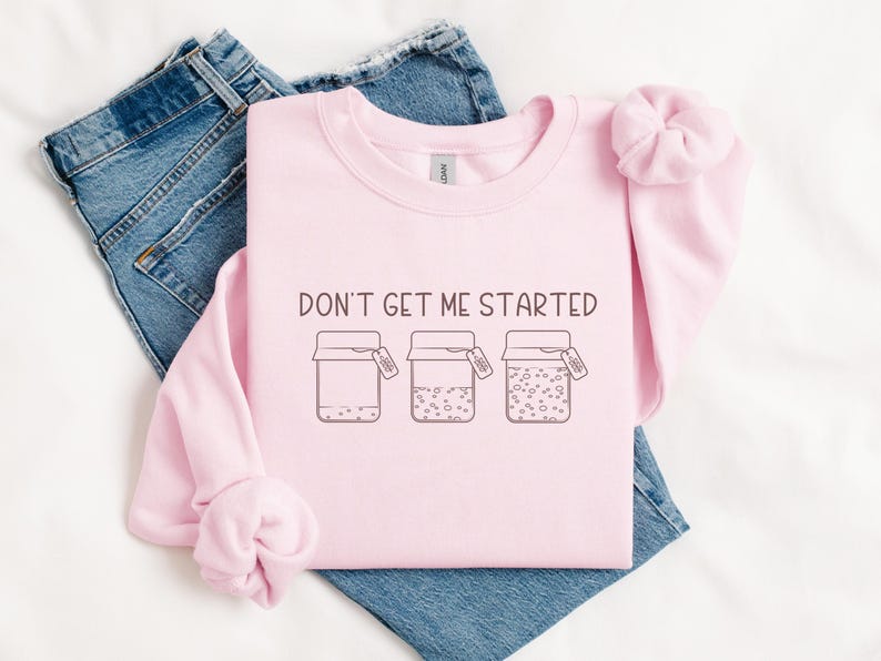 May include: Pink sweatshirt with the text "Don't get me started" and a graphic of three jars with lids. The jars are filled with different patterns.
